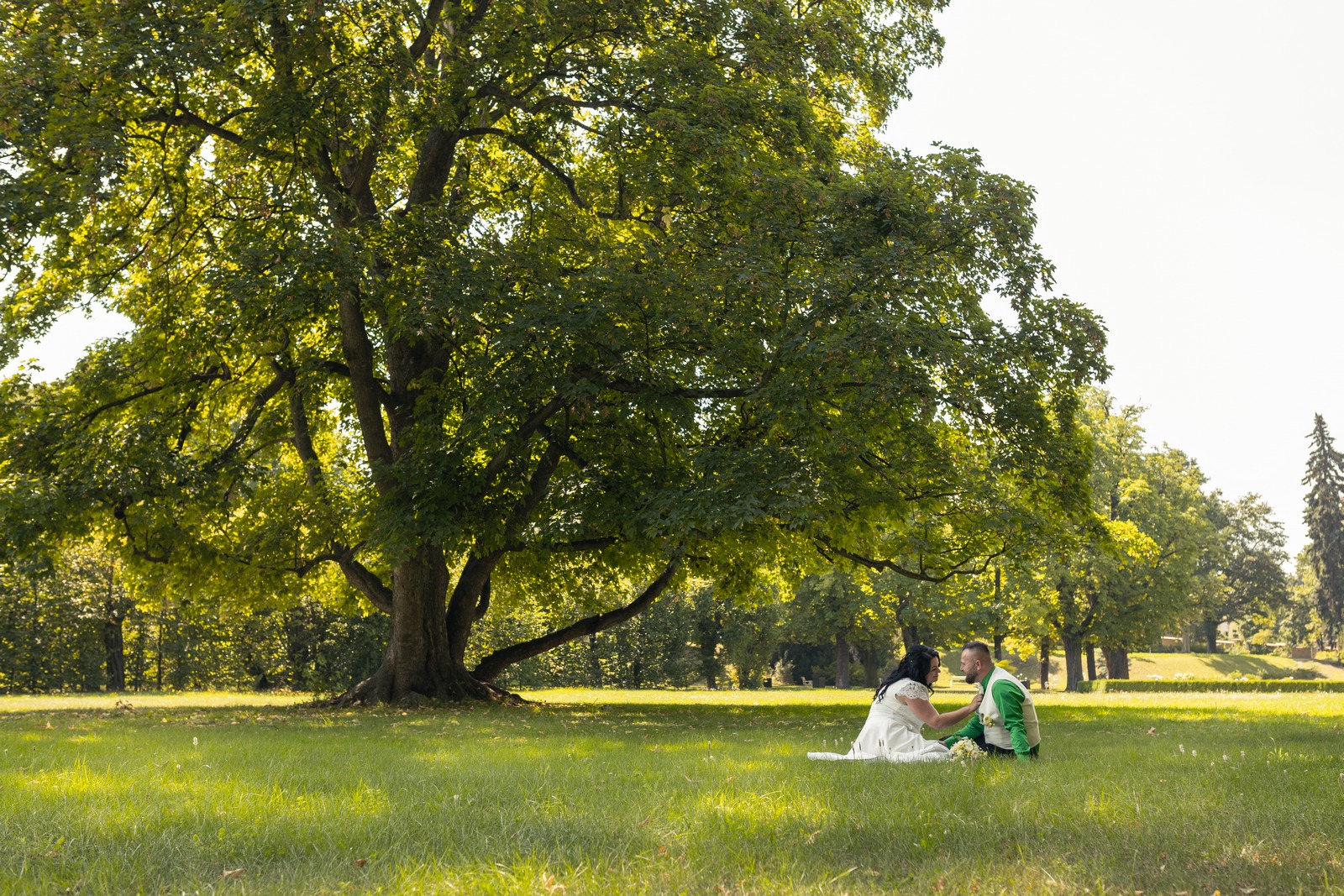 Svatba v Zámeckém parku v Hořovicích - ženich s nevěstou sedí pod stromem